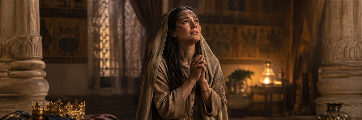 Esther kneels in mourning clothes and prays beside the crown and royal garments she has laid aside